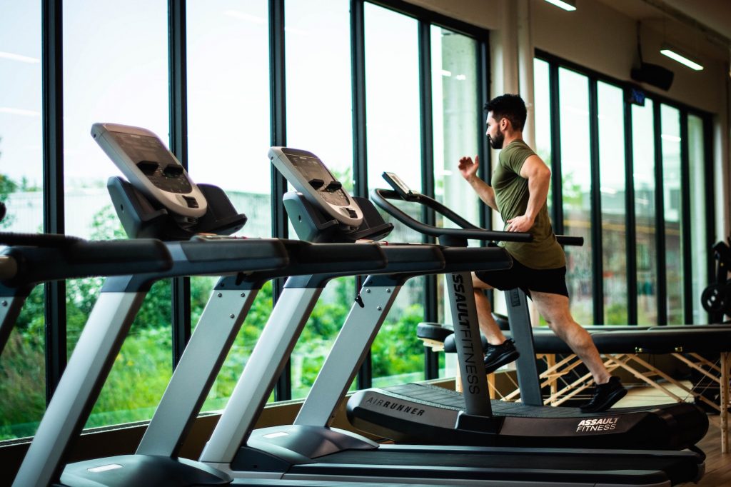 Man on treadmill aided by music. A key tool in the fitness industry.